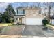 Tan two-story house featuring a white garage door and small front yard at 509 Tallwood Ct, Charlotte, NC 28216