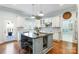 Kitchen island with seating, stainless steel appliances, and white cabinets at 6049 Bluebird Hill Ln, Weddington, NC 28104