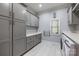 Laundry room with gray cabinets, washer, dryer, and utility sink at 6049 Bluebird Hill Ln, Weddington, NC 28104