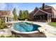 Luxury backyard oasis featuring a freeform pool, spacious patio, and pool house at 6049 Bluebird Hill Ln, Weddington, NC 28104