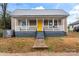 Tan colored house with a yellow door and front porch at 639 Harrison St, Statesville, NC 28677