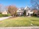 Two-story house with beige exterior, black shutters, and landscaping at 7704 Seton House Ln, Charlotte, NC 28277