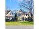 Two-story house with stucco exterior, landscaped lawn, and a two-car garage at 7704 Seton House Ln, Charlotte, NC 28277