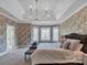 Spacious main bedroom with large windows, tray ceiling, and elegant floral wallpaper at 7704 Seton House Ln, Charlotte, NC 28277