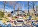 Charming backyard features a stone fire pit, inviting seating, and a pathway to the home's rear entrance at 7832 Winterset Dr, Charlotte, NC 28270