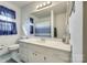 Bright bathroom featuring a large mirror, vanity with white cabinets, and blue accents at 7832 Winterset Dr, Charlotte, NC 28270