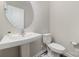 Clean bathroom with pedestal sink, toilet, and round mirror at 8928 Morning Mist Rd, Charlotte, NC 28215