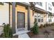 Townhome entrance with a gray door, brick facade, and well-maintained landscaping at 8928 Morning Mist Rd, Charlotte, NC 28215