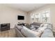 Open living area with gray sectional sofa, wood-looking floors, and a large TV at 8928 Morning Mist Rd, Charlotte, NC 28215