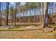 A large, grassy and wooded backyard features a bench and rock border at 1000 Weeping Willow Ln, Matthews, NC 28105