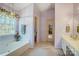 Bathroom with a large bathtub with natural light, and tile flooring at 1000 Weeping Willow Ln, Matthews, NC 28105