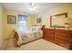 Bedroom with yellow walls, full bed, dresser, and large window with blue curtain at 1000 Weeping Willow Ln, Matthews, NC 28105