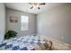 Neutral bedroom with a window view, a cozy quilt, and a green potted plant at 1000 Weeping Willow Ln, Matthews, NC 28105