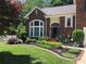 Beautiful brick home with lovely landscaping, a green lawn, and a welcoming entrance at 1000 Weeping Willow Ln, Matthews, NC 28105