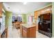 Well-lit eat-in kitchen with central island, wood cabinetry, and stainless steel refrigerator at 1000 Weeping Willow Ln, Matthews, NC 28105