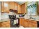 Kitchen features black appliances, granite countertops, a sink, and wood cabinets at 1000 Weeping Willow Ln, Matthews, NC 28105