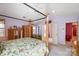 Spacious main bedroom with a four-poster bed, ceiling fan, and access to the ensuite bathroom at 1000 Weeping Willow Ln, Matthews, NC 28105