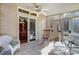 Bright sunroom features tile floors, white wicker furniture, and views into the dining room and the backyard at 1000 Weeping Willow Ln, Matthews, NC 28105