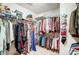 Organized walk-in closet with hanging clothes, shelving, and overhead storage at 1000 Weeping Willow Ln, Matthews, NC 28105