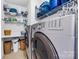 Bright laundry room with washer, dryer, and ample shelving at 13026 Serenity St, Huntersville, NC 28078