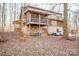 Back view of log cabin showcasing elevated deck and wooded setting at 148 Shawver Ln, Statesville, NC 28625