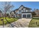 Two-story house with white brick exterior, gray garage doors, and manicured lawn at 18038 Greyfield Gln, Fort Mill, SC 29707