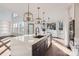 Large kitchen island with quartz countertop, dark cabinetry, and modern lighting at 18038 Greyfield Gln, Fort Mill, SC 29707