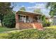 Welcoming brick home featuring a covered porch with metal railings, perfect for enjoying the outdoors at 1901 Ashcraft Ave, Monroe, NC 28110