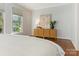 Bedroom with light walls, wood floors, and stylish dresser at 2031 Queens W Rd, Charlotte, NC 28207