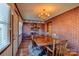 Bright dining room with brick accent wall, hardwood floors, and a wood table at 211 Roy Eaker Rd, Cherryville, NC 28021