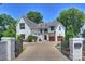 Luxury home with a white brick facade, gated entry, and a spacious driveway at 2714 Selwyn Ave, Charlotte, NC 28209