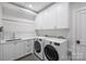 Bright laundry room with white cabinets and modern washer/dryer at 2714 Selwyn Ave, Charlotte, NC 28209