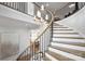 Modern curved staircase with metal railings and a large chandelier at 2714 Selwyn Ave, Charlotte, NC 28209