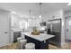 Modern kitchen with white cabinets, a large island, and stainless steel appliances at 30 Walnut Nw Ave, Concord, NC 28027