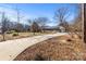 Long driveway leading to a ranch style home with mature trees at 322 Timber Rd, Iron Station, NC 28080