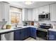 Modern kitchen with blue and white cabinets and stainless steel appliances at 322 Timber Rd, Iron Station, NC 28080