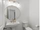 Modern bathroom with white pedestal sink and round mirror at 5774 Crown Ter, Hickory, NC 28601