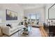 Bright living room with white sofas, large windows, hardwood floors, and modern decor at 5774 Crown Ter, Hickory, NC 28601