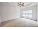 Bright bedroom with neutral carpet, tray ceiling, ceiling fan, and a large window with backyard view at 629 Cordova Ct, Salisbury, NC 28146