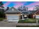 Charming home featuring a stone facade, white garage door and a manicured lawn at 629 Cordova Ct, Salisbury, NC 28146