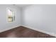 Simple bedroom with a window and dark wood floors at 646 Central Nw Dr, Concord, NC 28027