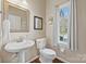 Clean and updated powder room with pedestal sink and hardwood floors at 6700 Fairhope Ct, Charlotte, NC 28277