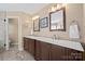 Double vanity bathroom with dark wood cabinets and a large mirror at 6700 Fairhope Ct, Charlotte, NC 28277