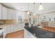 Modern kitchen with granite countertops, white cabinets, and access to backyard deck at 6700 Fairhope Ct, Charlotte, NC 28277