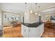 L-shaped kitchen island with granite countertop, white cabinets, and hardwood floors at 6700 Fairhope Ct, Charlotte, NC 28277