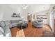 Open living room with hardwood floors, gray sectional sofa, and views to kitchen at 6700 Fairhope Ct, Charlotte, NC 28277