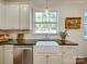 Modern kitchen with white cabinets, farmhouse sink, and dark countertops at 6706 Blackwood Ln, Waxhaw, NC 28173