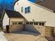 Two-car attached garage with neutral colored doors and stone accents at 680 Chase Ct, Fort Mill, SC 29708