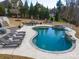 Freeform pool and spa with stone coping and surrounding patio at 680 Chase Ct, Fort Mill, SC 29708