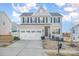 Two-story house with gray siding, white trim, and a three-car garage at 7067 Waterwheel Sw St, Concord, NC 28025